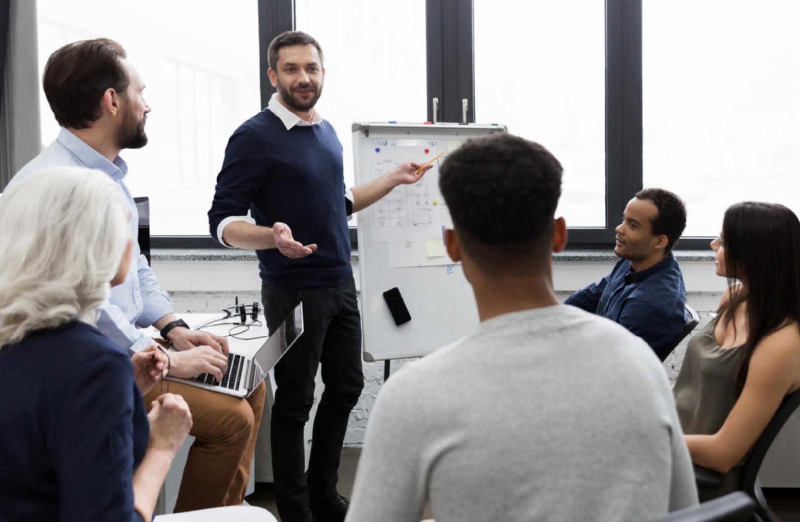 Person reviewing financial documents and charts on a desk with calculator and laptop