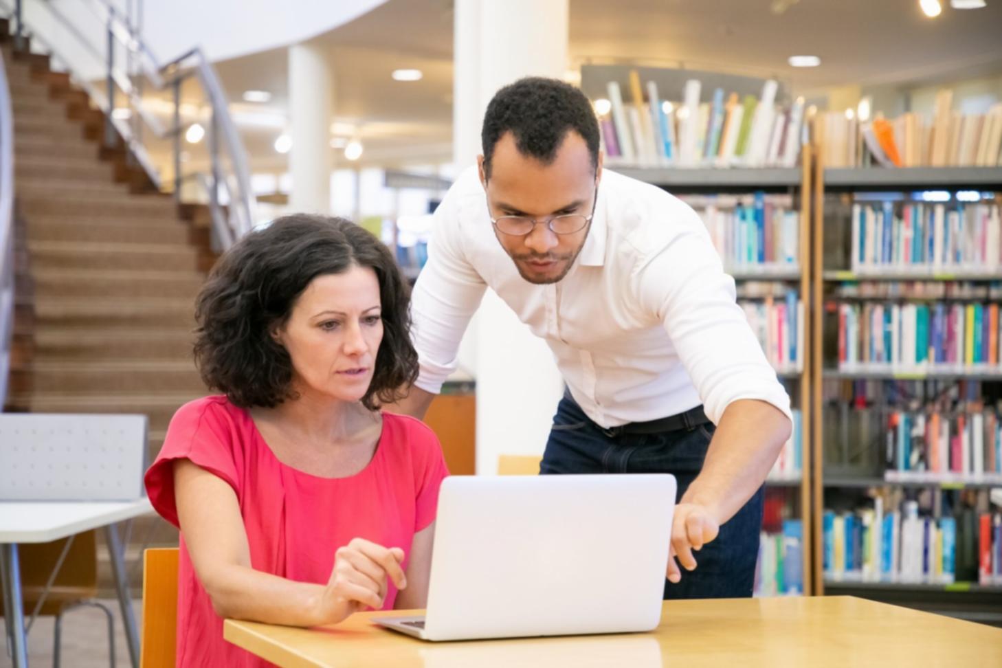 Interactive learning session showing budget deviation analysis on laptops with financial charts and data